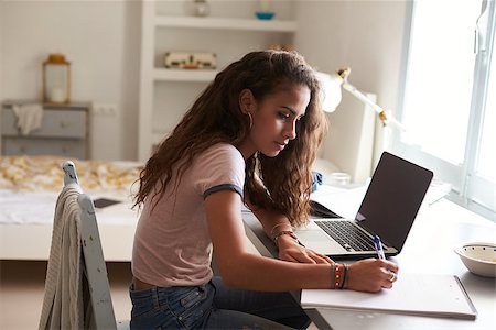 simsearch:400-06097939,k - Teenage girl doing homework at a desk in her bedroom Foto de stock - Super Valor sin royalties y Suscripción, Código: 400-08892353