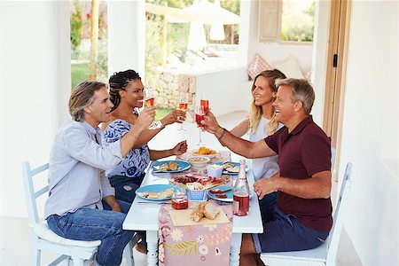 Two couples at a dinner table on a patio raise their glasses Stock Photo - Budget Royalty-Free & Subscription, Code: 400-08892425