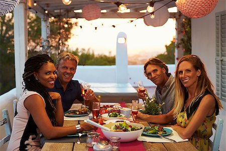 sunset meal - Two couples having dinner on a roof terrace look to camera Stock Photo - Budget Royalty-Free & Subscription, Code: 400-08892446