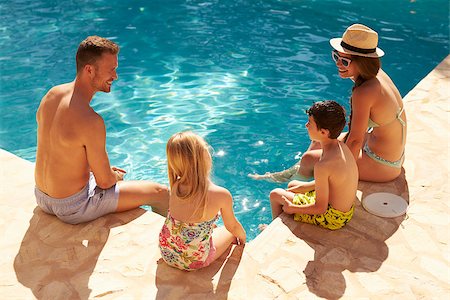 Rear View Of Family On Vacation Relaxing By Outdoor Pool Stock Photo - Budget Royalty-Free & Subscription, Code: 400-08892454