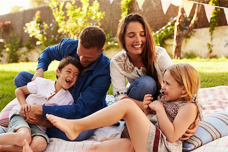 simsearch:400-08891803,k - Parents Playing Game With Children On Blanket In Garden Stock Photo - Budget Royalty-Free & Subscription, Code: 400-08892495