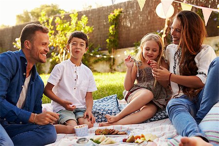 Family Enjoying Picnic On Blanket In Garden Stock Photo - Budget Royalty-Free & Subscription, Code: 400-08892501