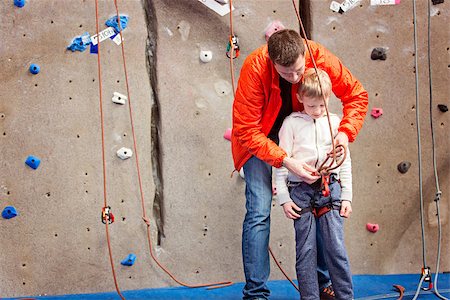 brave little boy ready for rock climbing at indoor climbing gym with his father helping, healthy and active lifestyle Photographie de stock - Aubaine LD & Abonnement, Code: 400-08892850