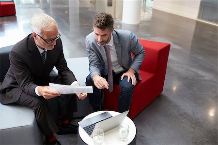 Two Businessmen Discuss Document In Lobby Of Modern Office Stock Photo - Budget Royalty-Free & Subscription, Code: 400-08937482