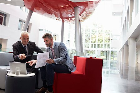 Two Businessmen Discuss Document In Lobby Of Modern Office Stock Photo - Budget Royalty-Free & Subscription, Code: 400-08937483