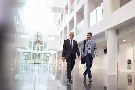 Businessmen Talking As They Walk Through Office Lobby Stock Photo - Budget Royalty-Free & Subscription, Code: 400-08937494