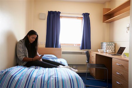Student Uses Mobile Phone In Bedroom Of Campus Accommodation Photographie de stock - Aubaine LD & Abonnement, Code: 400-08938130