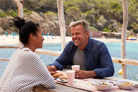 Middle aged couple sitting at table by the sea looking away Stock Photo - Budget Royalty-Free & Subscription, Code: 400-08938467