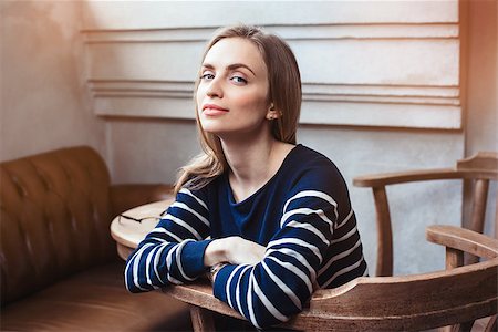 Portrait of smiling female hipster waiting for meeting with best friend while during coffee break in cafe. Grey wall background with copy space area for advertising content Stock Photo - Budget Royalty-Free & Subscription, Code: 400-08933734