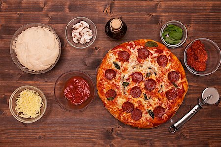 simsearch:400-08964146,k - Phases of making a pizza - the baked pizza ready to eat surrounded by the ingredients, top view Stock Photo - Budget Royalty-Free & Subscription, Code: 400-08959160