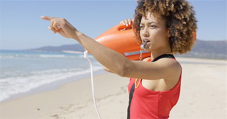 Lifeguard with rescue float blowing whistle and pointing with finger into distance. Tarifa beach. Provincia Cadiz. Spain. Stock Photo - Budget Royalty-Free & Subscription, Code: 400-08959275