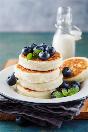 photos of blueberries for kitchen - Cottage cheese pancakes with blueberries and milk, homemade traditional Ukrainian and Russian cuisine. Selective focus Foto de stock - Super Valor sin royalties y Suscripción, Código: 400-08964014