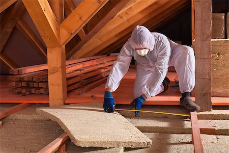 Man laying rockwool panels in the attic of a house - measuring the space between wooden scaffolding Stock Photo - Budget Royalty-Free & Subscription, Code: 400-08964973