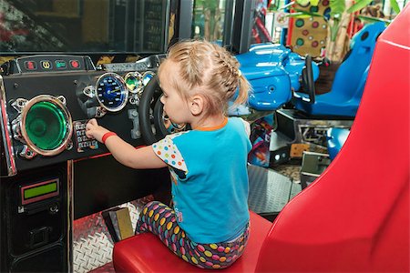 simulation - Little girl at the wheel of the game simulator presses the buttons Stock Photo - Budget Royalty-Free & Subscription, Code: 400-08966520