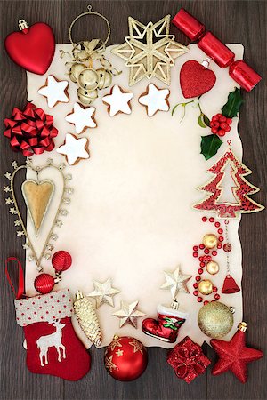 Christmas festive background border with bauble decorations, holly, mistletoe, gingerbread biscuits on parchment paper on oak wood. Stock Photo - Budget Royalty-Free & Subscription, Code: 400-08968506