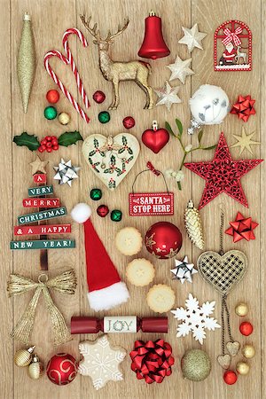 Christmas decorative symbols with new and old fashioned bauble decorations, holly, mistletoe, gingerbread biscuit and mince pies on light oak wood background. Stock Photo - Budget Royalty-Free & Subscription, Code: 400-08968500