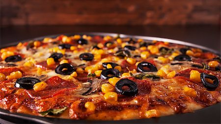 simsearch:400-08964146,k - Freshly baked delicious pizza in baking pan - closeup with copy space above, low key Stock Photo - Budget Royalty-Free & Subscription, Code: 400-08960199