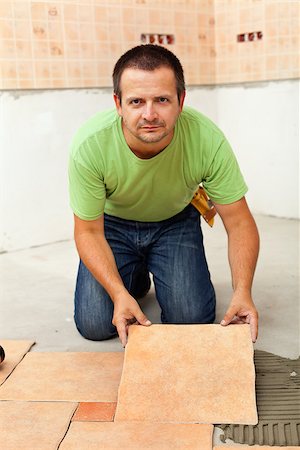 Man laying ceramic floor tiles - placing the next one into position Photographie de stock - Aubaine LD & Abonnement, Code: 400-08960192