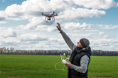 man operating of flying drone quadrocopter at the green field. Stock Photo - Budget Royalty-Free & Subscription, Code: 400-08962000
