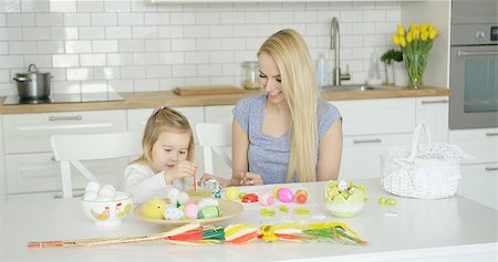 Charming woman and little girl coloring Easter eggs together while sitting by table at light modern kitchen. Stock Photo - Budget Royalty-Free & Subscription, Code: 400-08962178