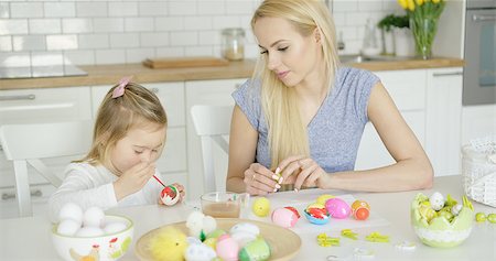 Little girl coloring Easter eggs and young beautiful mother sitting near and watching in light modern kitchen. Stock Photo - Budget Royalty-Free & Subscription, Code: 400-08962185