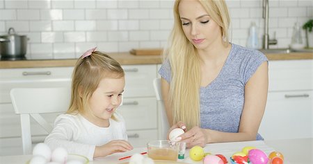 Laughing little girl coloring Easter egg with help of young mother while sitting at table at kitchen. Stock Photo - Budget Royalty-Free & Subscription, Code: 400-08962181