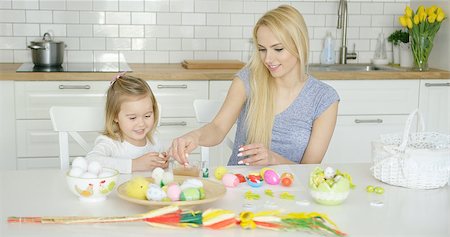 Attractive woman sitting at table with little girl and coloring Easter eggs together at light modern kitchen. Stock Photo - Budget Royalty-Free & Subscription, Code: 400-08962182
