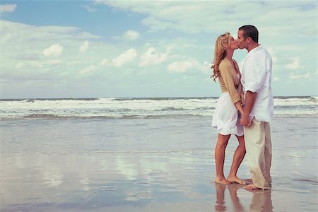 simsearch:400-06751687,k - Instagram style photograph of romantic young man and woman couple holding hands and kissing on a beach Stock Photo - Budget Royalty-Free & Subscription, Code: 400-08962275