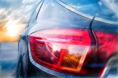 phantom1311 (artist) - A collage of a back lantern of the car and a rising sun in a background with a shallow depth of field Stock Photo - Budget Royalty-Free & Subscription, Code: 400-08962542