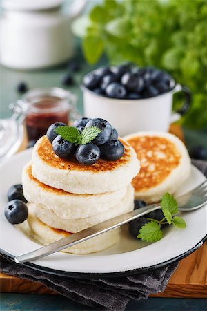 photos of blueberries for kitchen - Cottage cheese pancakes with blueberries and mint, homemade traditional Ukrainian and Russian cuisine. Selective focus Stock Photo - Budget Royalty-Free & Subscription, Code: 400-08962997