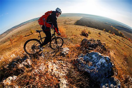 simsearch:400-05681317,k - Wide angle view of a cyclist riding a bike on a nature trail in the mountains. people living a healthy lifestyle. Cyclist in the helmet and glasses. Fisheye. Landscape with hill, mound, horizon and blue sky. Stock Photo - Budget Royalty-Free & Subscription, Code: 400-08996905