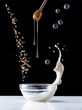 fascinadora (artist) - Falling granola with milk splash, falling blueberries and honey flows from dipper. Healthy breakfast ingredients. Flying food Stock Photo - Budget Royalty-Free & Subscription, Code: 400-08996972