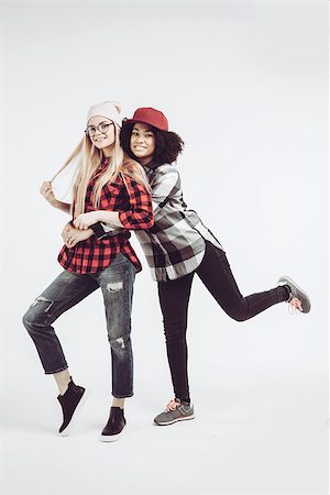 Studio lifestyle portrait of two best friends hipster girls wearing stylish bright outfits, going crazy and having great time together. Isolated on white background. Stock Photo - Budget Royalty-Free & Subscription, Code: 400-08997046