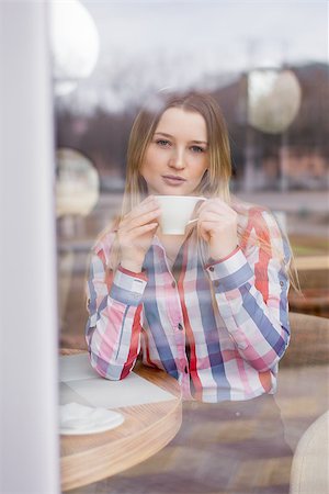 through the glass the girl in the cafe drinking coffee Stockbilder - Microstock & Abonnement, Bildnummer: 400-09008572