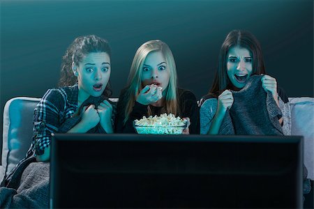 family movie night popcorn - Teenage girls watching horror movie with popcorn Stock Photo - Budget Royalty-Free & Subscription, Code: 400-09009174
