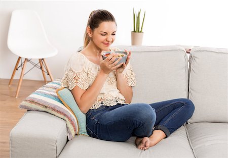 pretty women eating banana - Beautiful woman at home smelling her bowl full of healthy food Photographie de stock - Aubaine LD & Abonnement, Code: 400-09009880
