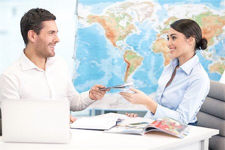 Young man tour agent giving passports and tickets to customer Stock Photo - Budget Royalty-Free & Subscription, Code: 400-09019089