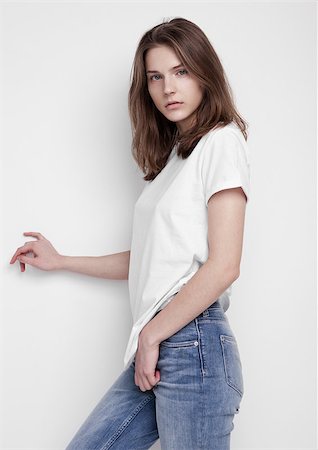 simsearch:400-04392351,k - Model test portrait with young beautiful fashion model posing on grey background. Wearing white t-shirt and jeans. Foto de stock - Super Valor sin royalties y Suscripción, Código: 400-09019324