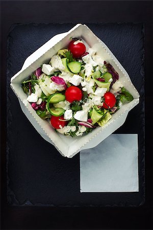 shyrix (artist) - Greek salad with brynza top view. Exhibited on a black slate, near the place for the inscription. Stockbilder - Microstock & Abonnement, Bildnummer: 400-09019668