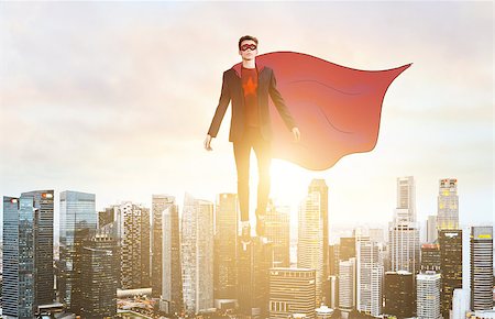 Business superhero. Businessman hovering over down town on sunset. Foto de stock - Super Valor sin royalties y Suscripción, Código: 400-09010290