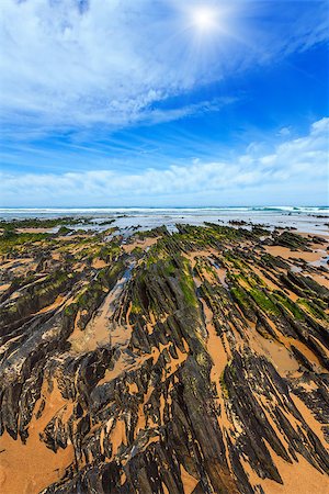 simsearch:400-08817566,k - Rock formations on sunshiny sandy beach and blue sky with cumulus clouds (Algarve, Costa Vicentina, Portugal). Photographie de stock - Aubaine LD & Abonnement, Code: 400-09010358