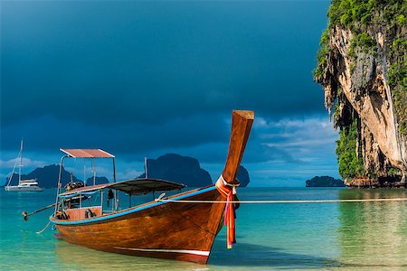 simsearch:400-07245917,k - A Thai boat with a long tail near the shore, a blue rain cloud over the Andaman Sea Fotografie stock - Microstock e Abbonamento, Codice: 400-09010724