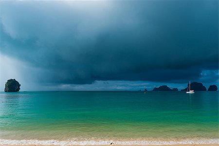 simsearch:400-09010474,k - calm sea and rain clouds in front of a tropical rain, the boat into the sea with deflated sails Stockbilder - Microstock & Abonnement, Bildnummer: 400-09010726