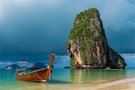 Traditional wooden Thai boat near the shore and high cliff Stock Photo - Budget Royalty-Free & Subscription, Code: 400-09010723