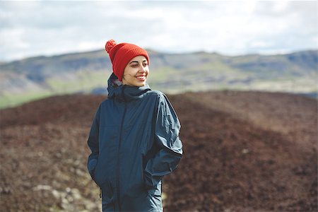 Girl in warm clothing observing surroundings on background of mountains of Iceland. Fotografie stock - Microstock e Abbonamento, Codice: 400-09011568