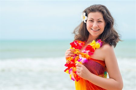 Happy young brunette in pareo and flower lei against the sea Photographie de stock - Aubaine LD & Abonnement, Code: 400-09011561