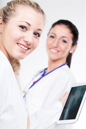 data security screens - couple of smiling doctors and a digital tablet, they're two proud women ready to help Stock Photo - Budget Royalty-Free & Subscription, Code: 400-09028278