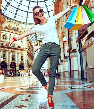 Discover most unexpected trends in Milan. Full length portrait of happy fashion monger in eyeglasses with colorful shopping bags having fun time in Galleria Vittorio Emanuele II Stock Photo - Budget Royalty-Free & Subscription, Code: 400-09028471