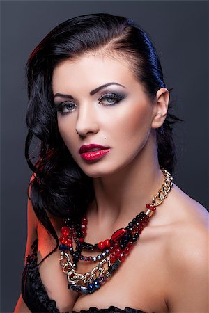 simsearch:400-04974367,k - Beautiful brunette young woman with bright make-up and red lips wearing necklace. Copy space. Photographie de stock - Aubaine LD & Abonnement, Code: 400-09028704