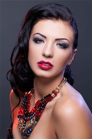 simsearch:400-04974367,k - Beautiful brunette young woman with bright make-up and red lips wearing necklace. Copy space. Photographie de stock - Aubaine LD & Abonnement, Code: 400-09028706